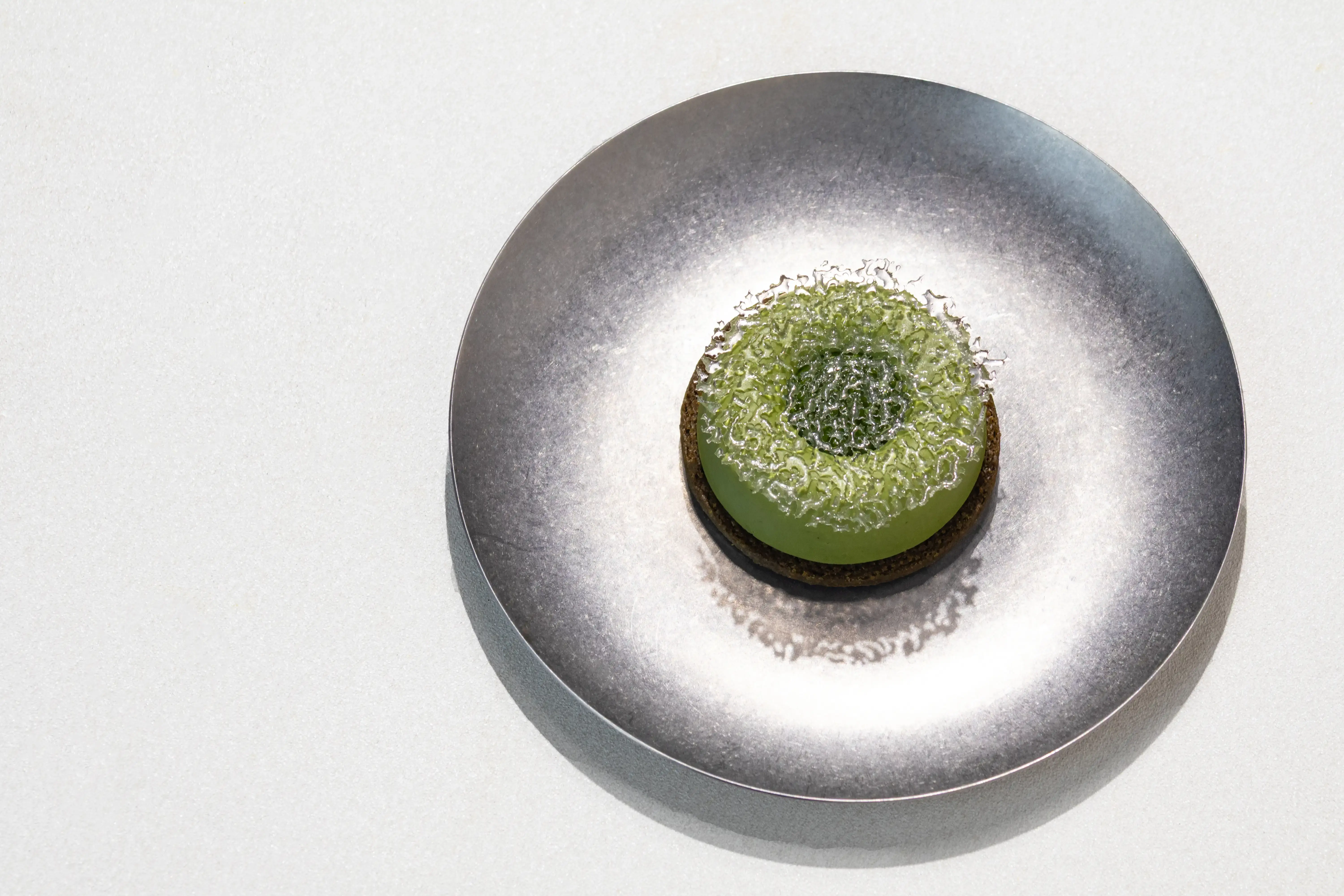 圖13 小小樹食｜限定甜點「抹茶之森」 以抹茶沙布列為底，透明糖片映照如冬夜薄霧的光，凝結森林深處的靜謐與未知